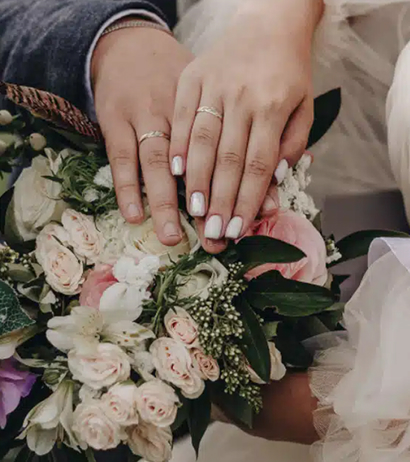 A close-up wedding shot of a couples wedding rings and bouquet